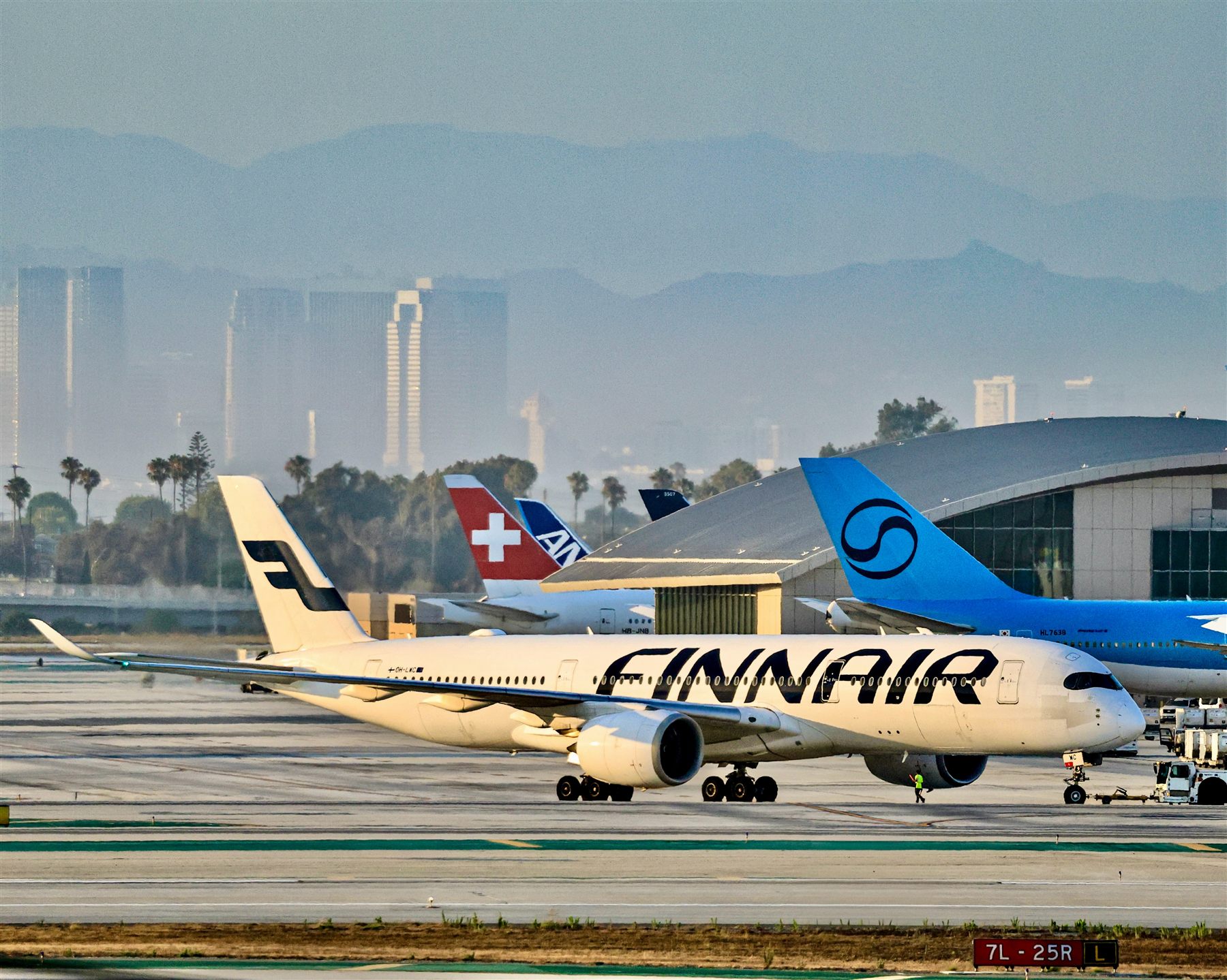 Commercial aircraft climbing above a city skyline